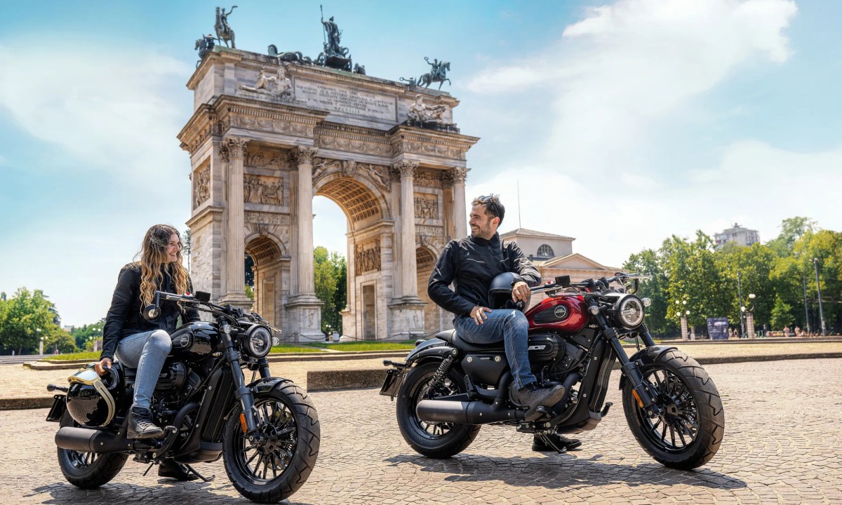 Two people on 2025 Benda Chinchilla 300s parked talking in fron to f the Arch de Triumph in Paris.