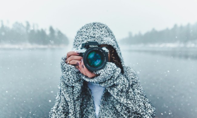 Woman taking a photo in a snowy landscape