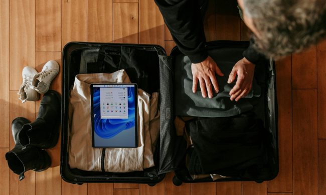 An overhead view of a man packing a suitcase