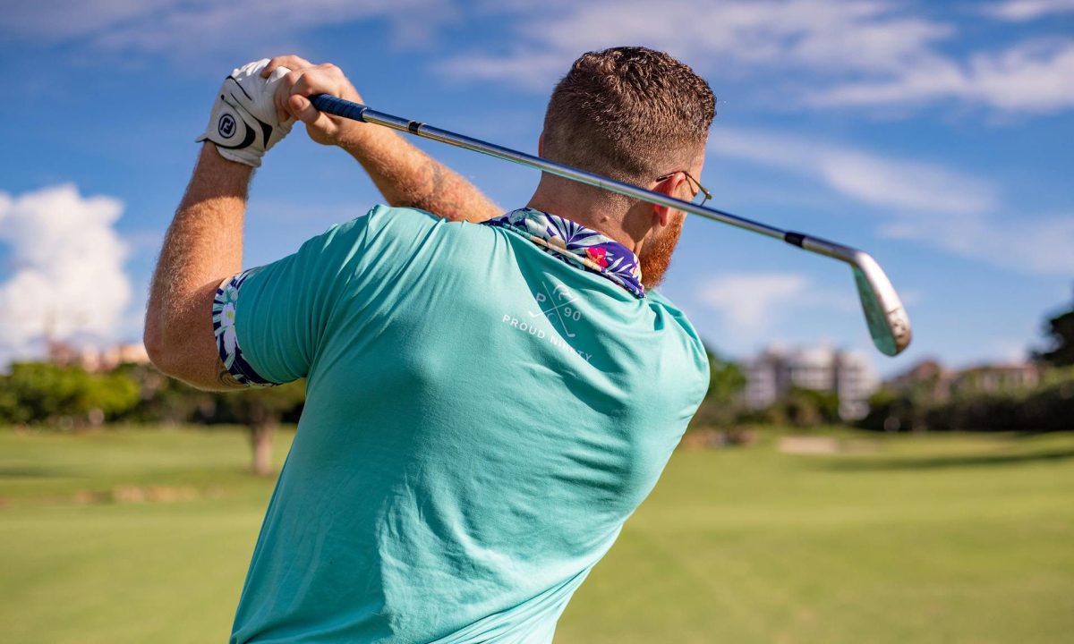 man playing golf swinging club