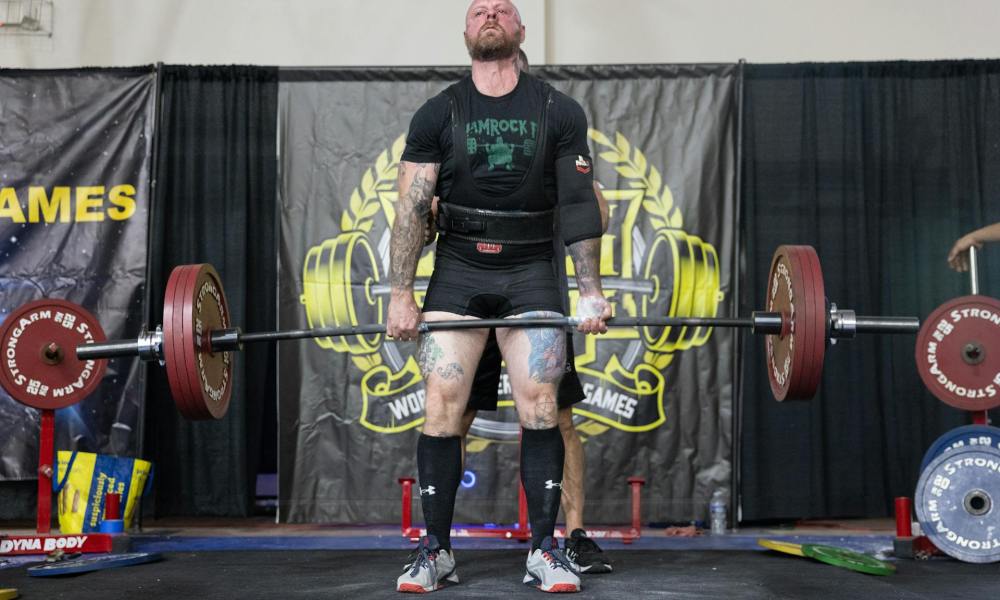 man powerlifting dead lift holding barbell competition