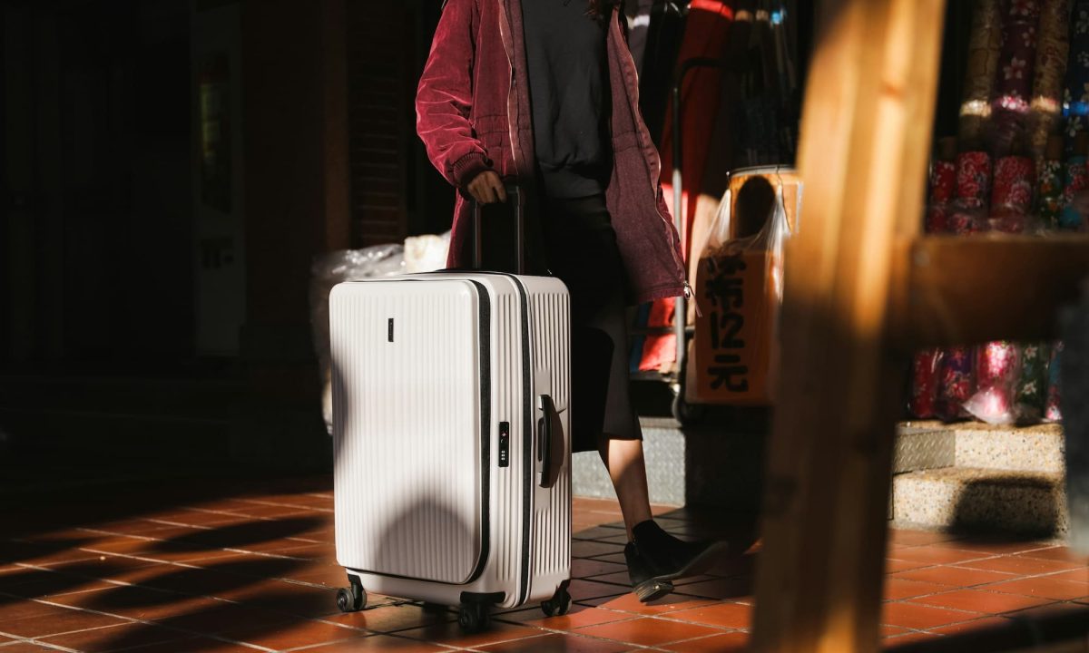 person rolling white suitcase