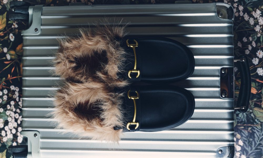 black loafer on top of suitcase