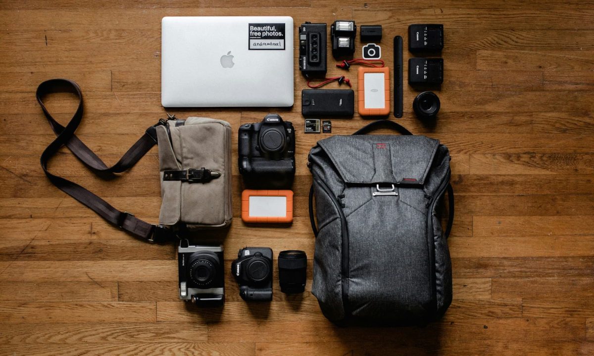 dslr camera gear and backpack sitting on wood floor