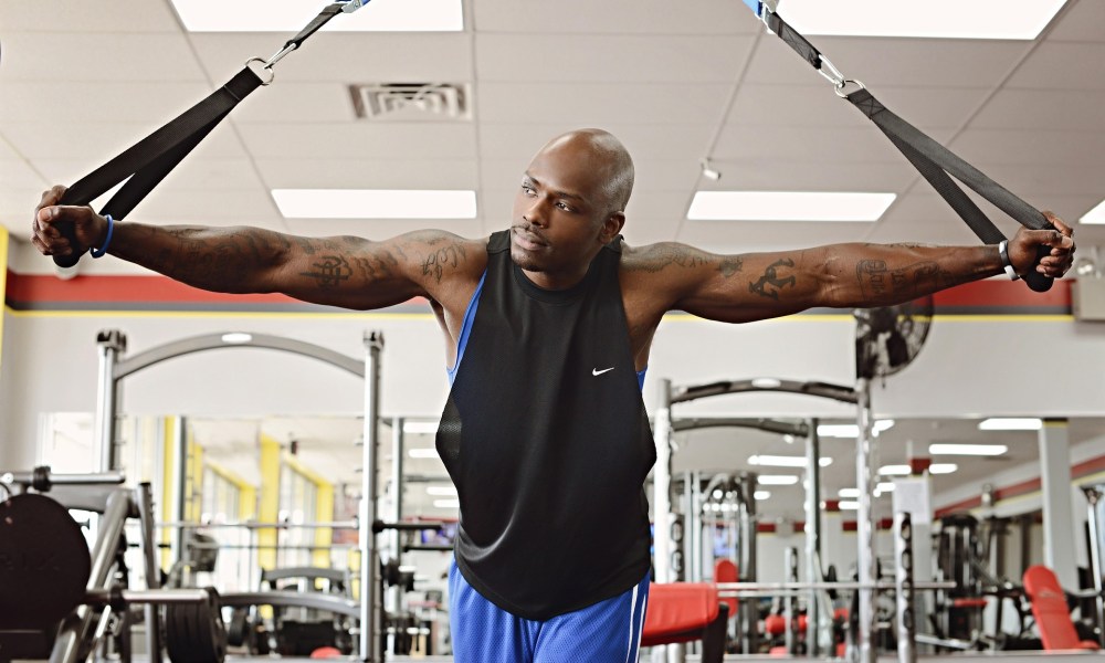 man in gym using bands thinking happy